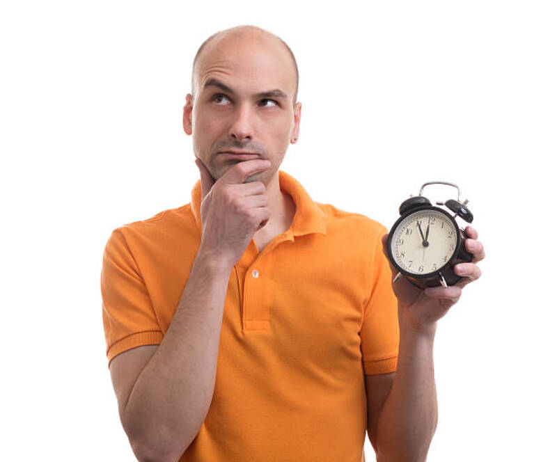 man holding an alarm clock