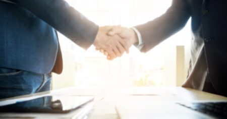 The Partnership Between Bally’s Interactive and Gaming Realms Two Businessmen Shake Hands